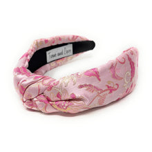 Load image into Gallery viewer, Pink satin headband with gold floral embroidery and a twisted knot design. The headband is set against a white background, conveying elegance.