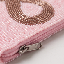Load image into Gallery viewer, Close-up of a pink beaded clutch or wallet with a silver zipper pull.