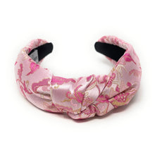 Load image into Gallery viewer, Pink satin headband with gold floral embroidery and a twisted knot design. The headband is set against a white background, conveying elegance.