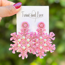Load image into Gallery viewer, Pink beaded snowflake earrings with pearl accents on a white background. The intricate design is festive and elegant, highlighting craftsmanship.