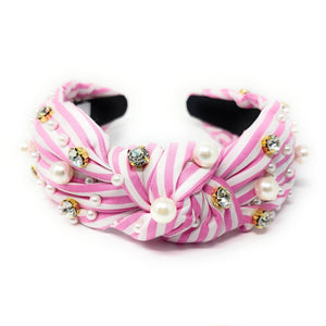 Pink and white striped headband with pearls and crystals on a white background