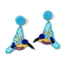 Load image into Gallery viewer, Close-up portrait featuring a sky-blue twist headband paired with handcrafted bird-shaped earrings in turquoise, purple, and gold beadwork.