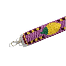 Load image into Gallery viewer, A purple beaded keychain strap featuring a yellow lemon design with a green leaf, finished with a gold metal lobster clasp, shown on a plain white background.