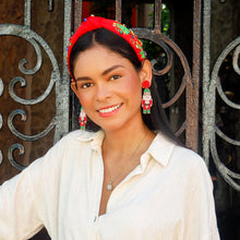 Load image into Gallery viewer, Woman in a white shirt standing in front of an ornate metal gate