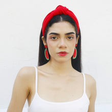 Load image into Gallery viewer, A fashion model wearing watermelon earrings and a white top against a white background.