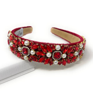Elegant red headband adorned with intricate red crystals, pearls, and gold accents, conveying a luxurious and sophisticated tone.