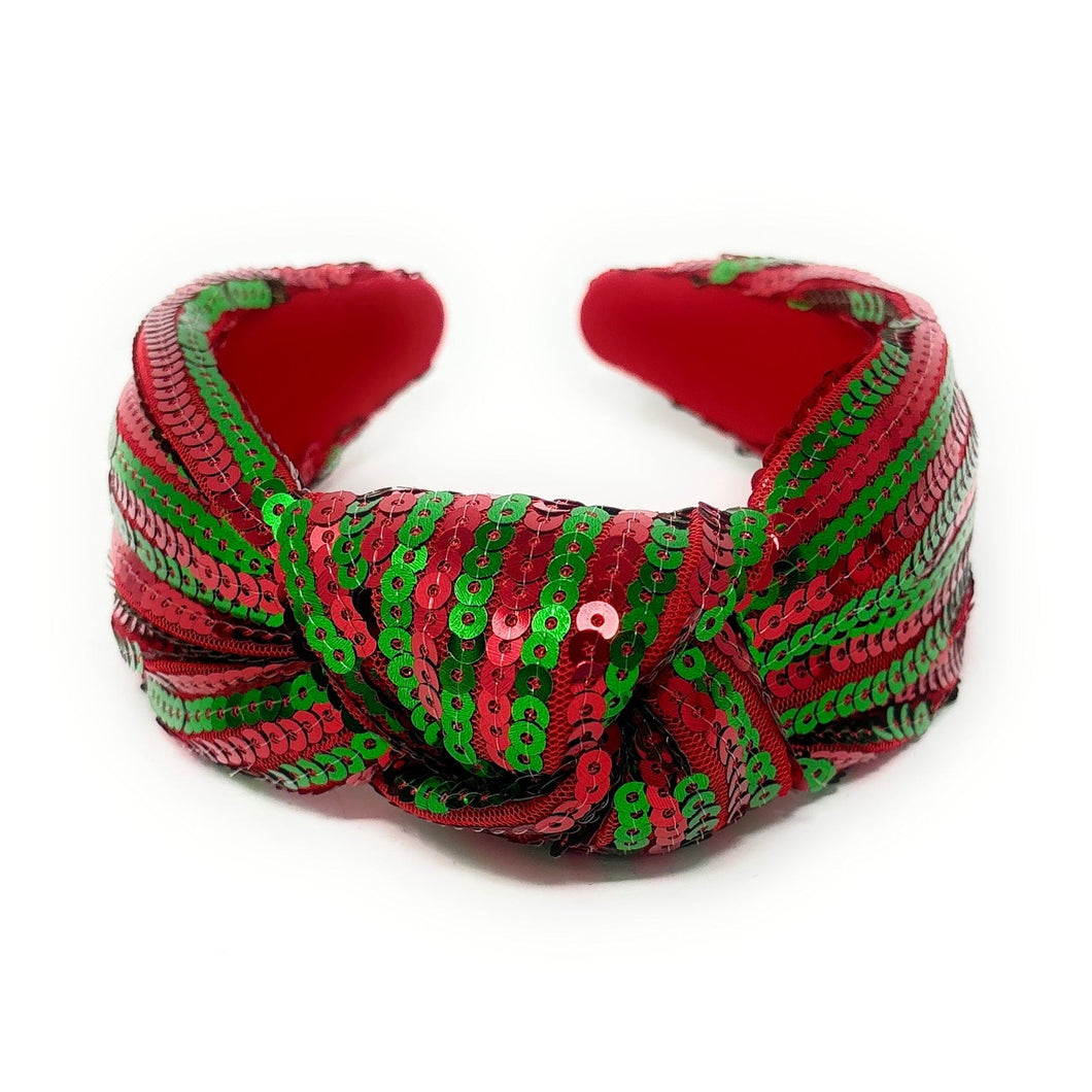 A vibrant headband adorned with alternating red and green sequins, forming a knot at the center. The design creates a festive, cheerful vibe.
