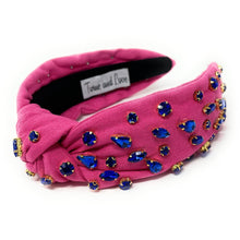 Load image into Gallery viewer, Fashion portrait of a woman wearing a bright pink embellished headband and navy crystal statement earrings outdoors.