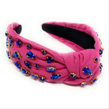 Load image into Gallery viewer, Woman wearing a vibrant pink jeweled headband paired with navy crystal statement earrings in an outdoor setting.