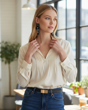 Load image into Gallery viewer, Woman wearing a white blouse and blue jeans indoors with a blurred background