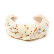 Load image into Gallery viewer, Ivory-colored headband with a floral pattern in orange and green. It has a knotted design and visible label inside. Elegant and playful tone.