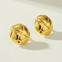 Load image into Gallery viewer, A pair of gold-tone stud earrings with a textured, segmented floral or geometric design, displayed on a clean off-white surface with soft shadows.