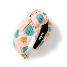 Load image into Gallery viewer, A pink fabric headband with a knotted center and a seashell pattern in teal, yellow, and white, shown on a white background with a soft shadow.