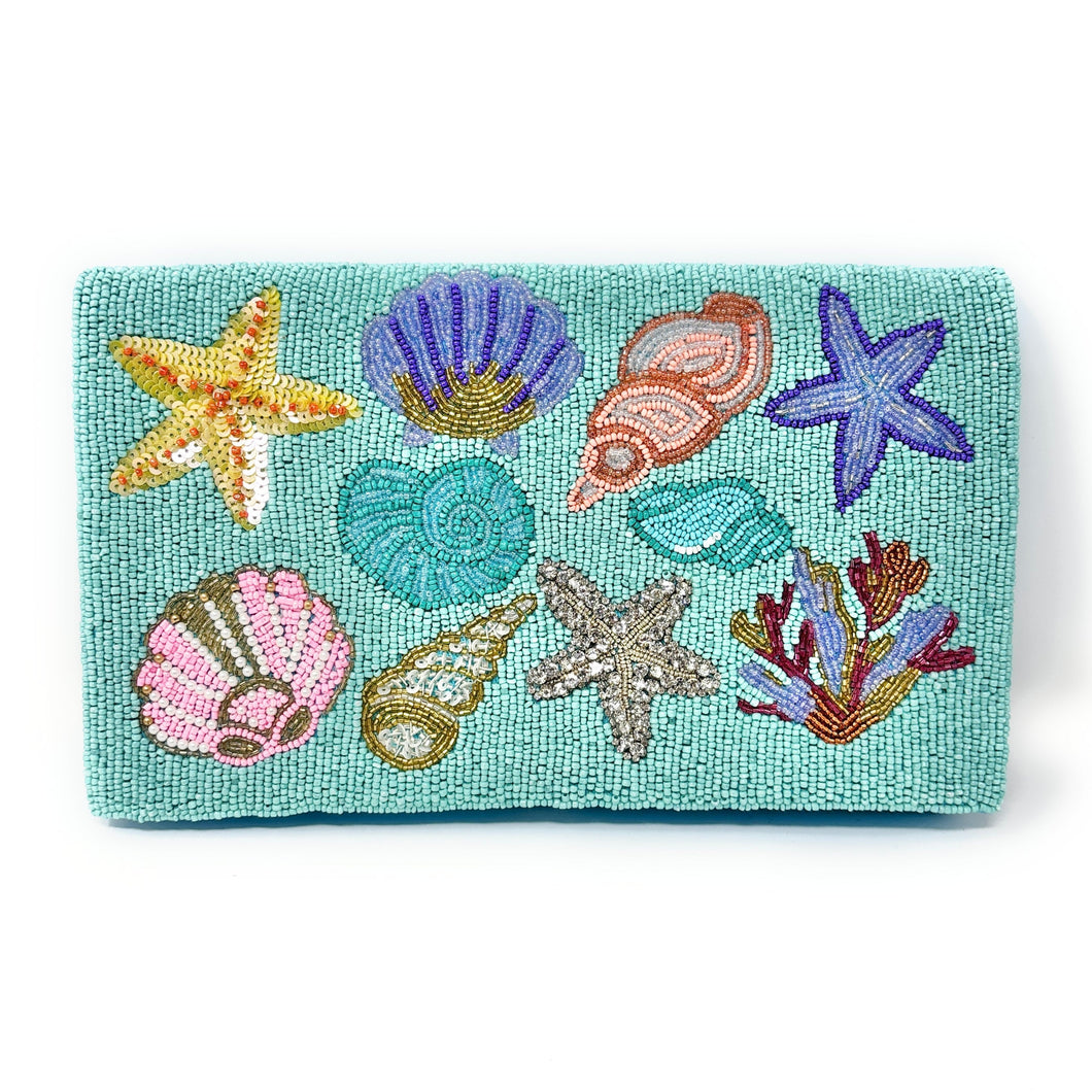 Colorful beaded clutch featuring shells, starfish, and coral on a turquoise background. The vibrant design conveys a lively, ocean-themed vibe.
