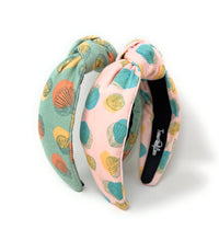 Load image into Gallery viewer, Two knotted fabric headbands with a seashell pattern, one in sage green and one in light pink, displayed on a white background.