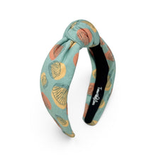 Load image into Gallery viewer, A knotted fabric headband in a dusty teal blue-green color, decorated with a pattern of yellow, orange, and blue seashells. The inner band is black with white branding text that reads 'Twine and Love'.