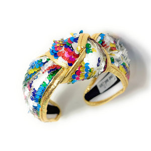 Gold padded headband adorned with colorful sequins, displaying a vibrant, playful design. 