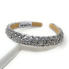 Load image into Gallery viewer, Silver headband with a floral crystal pattern, set on a white display. The inside is tan with a fabric label. Elegant and sparkling design.