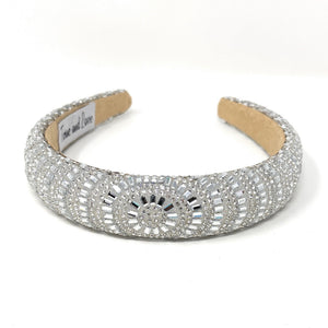 Elegant silver headband adorned with sparkling, intricate patterns and rhinestones, reflecting light. 