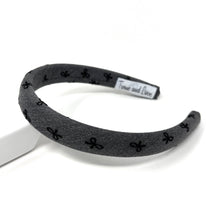 Load image into Gallery viewer, Black headband with black bow patterns on a white background