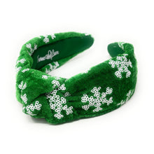 Load image into Gallery viewer, Green velvet headband adorned with white snowflake patterns. The texture is soft and plush, giving a festive, cheerful vibe against a plain white background.