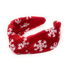 Load image into Gallery viewer, Red velvet headband adorned with white snowflake patterns. The texture is soft and plush, giving a festive, cheerful vibe against a plain white background.