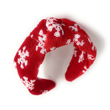 Load image into Gallery viewer, Red velvet headband adorned with white snowflake patterns. The texture is soft and plush, giving a festive, cheerful vibe against a plain white background.