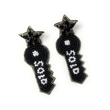 Load image into Gallery viewer, Black star earrings with geometric key design, adorned with white beaded accents. The glossy texture and intricate pattern create a bold, stylish look.