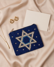 Load image into Gallery viewer, Navy blue hand-beaded Star of David pouch styled on soft fabric with gold jewelry and a blank gift card.