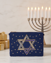 Load image into Gallery viewer, Elegant navy blue Star of David beaded pouch displayed with a traditional Hanukkah menorah and festive decorations.