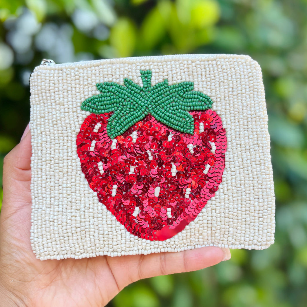 A beaded pouch with a zipper, featuring a vibrant red strawberry with green leaves on a textured beige background. Whimsical and playful design.