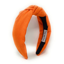 Load image into Gallery viewer, Burnt orange padded headband with a twisted knot detail, styled with sleek hair and statement gold earrings.
