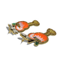 Load image into Gallery viewer, Pair of earrings with orange center and gold accents on a white background