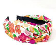 Load image into Gallery viewer, Smiling woman wearing a colorful floral print headband paired with bold yellow flower statement earrings outdoors.