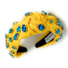 Load image into Gallery viewer, Close-up of a model wearing a vibrant yellow crystal headband with glamorous aqua statement earrings outdoors.