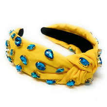 Load image into Gallery viewer, Woman wearing a yellow crystal-embellished headband with turquoise statement earrings and a green halter top outdoors.