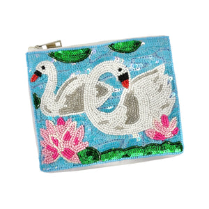Hand beaded pouch with two white swans, pink flowers, and green leaves on a blue background. 
