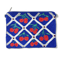 Load image into Gallery viewer, Hand-beaded cherry pouch featuring vibrant red cherries, white lattice detailing, and a bold royal blue background for a playful statement look.