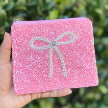 Load image into Gallery viewer, Pink beaded zip pouch with pearl bow design held against greenery background