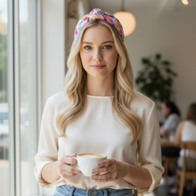 Load image into Gallery viewer, A woman in a cafe, wearing a valentines headband and white blouse, holds a coffee cup. Sunlight streams through large windows. The mood is calm and inviting.