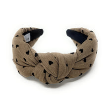 Load image into Gallery viewer, tan headband with black heart patterns on a white background