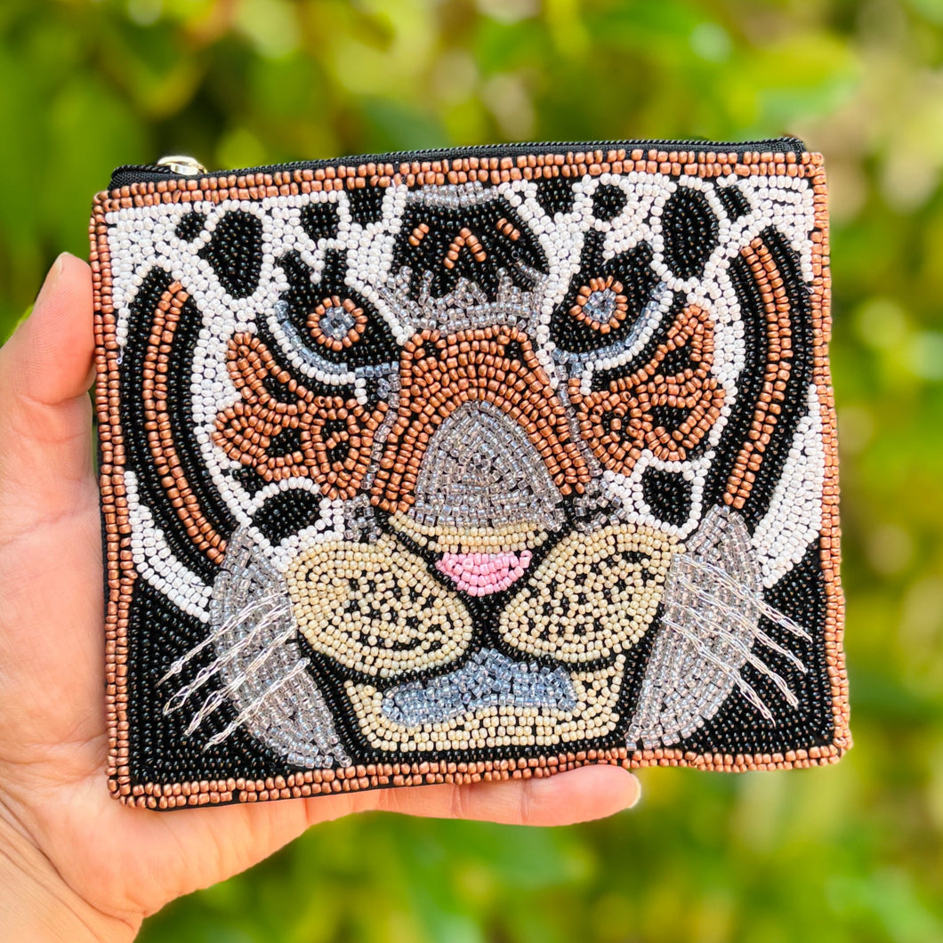Beaded pouch depicting a tiger's face, made with intricate brown, black, white, and blue beads. The design is vibrant and expressive, with a gold zipper.