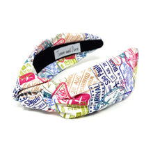 Load image into Gallery viewer, Twist knot headband with a vibrant travel print showcasing passport stamps, destinations, and aviation-inspired details.