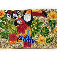 Load image into Gallery viewer, A rectangular clutch bag covered in gold sequins and decorated with colorful embroidered tropical birds, including a toucan and parrot, along with green leaves and yellow flowers, shown on a plain white background.