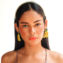 Load image into Gallery viewer,  A fashion model showcasing vibrant yellow earrings and a stylish outfit