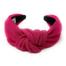 Load image into Gallery viewer, Woman wearing a vibrant fuchsia knotted headband with a black ruffle dress and colorful statement earrings.