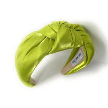 Load image into Gallery viewer, A vibrant green satin headband with a twisted knot design, labeled &quot;Twine and Love&quot; inside. The fabric&#39;s sheen adds a touch of elegance.