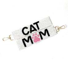 Load image into Gallery viewer, White beaded keychains with "CAT MOM" in black letters, featuring a pink paw print. Gold clasps attached. Playful and pet-themed design.