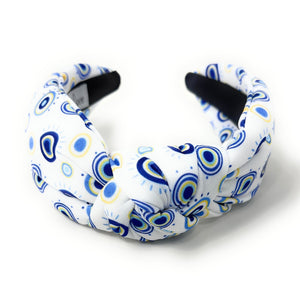 A white padded headband features a blue and yellow concentric circle pattern, exuding a playful vibe.