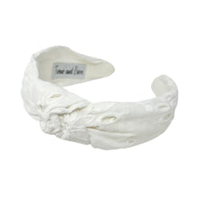 Load image into Gallery viewer, White headband with intricate white floral embroidery, displayed in a side view. The soft texture and elegant design convey a stylish, timeless appeal.